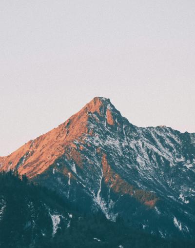 Sunlit mountain peak above a layer of mist